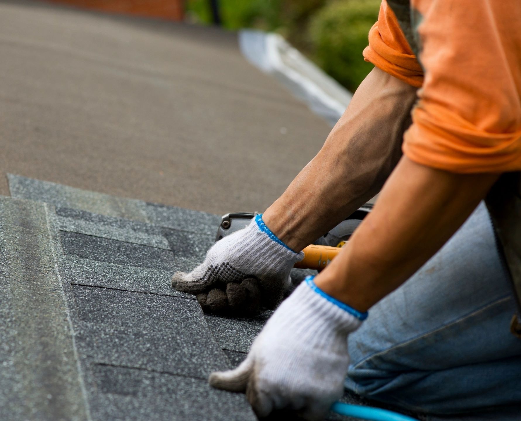 Workers installing asphalt shingles