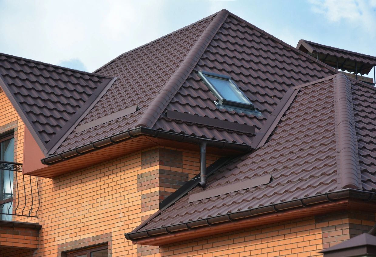 Residential roof with dark metal tiles and skylight